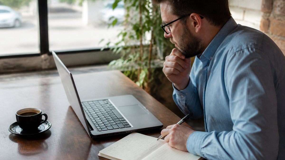 Business owner analyzing marketing channel metrics on a laptop to lower customer acquisition costs